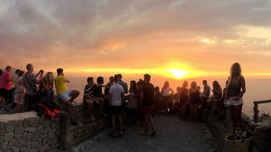 Urlauber sitzen am 10.08.2016 auf einer Mauer am Strand von Sa Foradada auf Mallorca (Spanien) und genießen den Sonnenuntergang. Foto: Alberto Magro/dpa (zu dpa «Mallorca: Eine Insel am Limit» vom 06.09.2016) +++(c) dpa - Bildfunk+++
