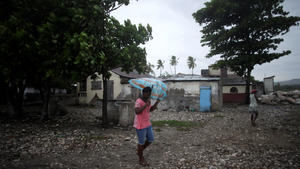A woman protects herself from rain as Hurricane Matthew approaches in Les Cayes, Haiti, October 3, 2016. REUTERS/Andres Martinez Casares