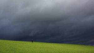 Eine Frau steht am Samstag (06.11.2010) auf einer Wiese in Sundern-Endorf (Hochsauerlandkreis), während am Himmel dunkle Wolken vorüberziehen. Für die nächsten Tage sagen die Meteorologen weiterhin trübes Herbstwetter voraus. Foto: Julian Stratenschulte dpa/lnw  +++(c) dpa - Bildfunk+++