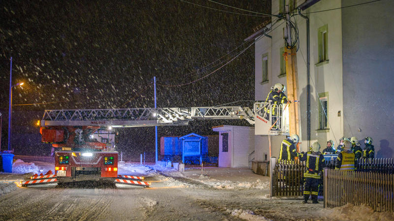 Feuerwehrleute richten in der Nacht zum 04.01.2017 in Großerkmannsdorf (Sachsen) einen Telefonmast, der nach einem Unfall umzustürzen droht. Foto: Rico Loeb/dpa-Zentralbild/dpa +++(c) dpa - Bildfunk+++