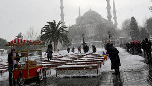 People stroll at the snow-covered Sultanahmet square in Istanbul, Turkey January 8, 2017. The Ottoman-era Sultanahmet mosque, known as the Blue mosque is seen in the background. REUTERS/Murad Sezer
