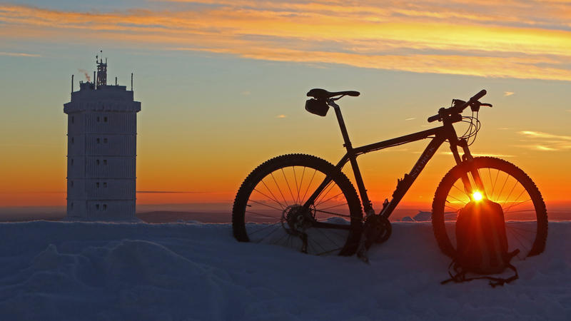 Ein Fahrrad steht am 06.01.2017 auf dem Brocken (Sachsen-Anhalt) im Licht der aufgehenden Sonne. Der Berg im Harz ist mit einer Temperatur von Minus 21 Grad am Freitag der kälteste Ort in Norddeutschland. Foto: Matthias Bein/dpa-Zentralbild/dpa +++(c