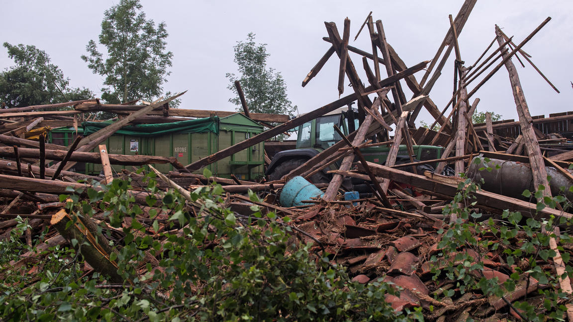 Ein Traktor mit Anhänger steht am 08.07.2017 in einem völlig zerstörten Geräteschuppen in Goldenstedt (Niedersachsen). Nach einem schweren Unwetter am Vorabend glich die kleine Ortschaft stellenweise einem Trümmerfeld.