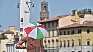 dpatopbilder - Ein duschender Mann trägt am 01.08.2017 in Florenz (Italien) einen Regenschirm-Hut in den italienischen Nationalfarben. In Süd- und Zentralitalien herrscht derzeit eine Hitzewelle mit Temperaturen bis zu 40 Grad Celsius. Foto: Maurizio Degl'innocenti/ANSA/AP/dpa +++(c) dpa - Bildfunk+++