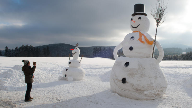 Eine Frau fotografiert am 10.01.2017 in Eibenstock (Sachsen) einen 6,50 Meter großen Schneemann. Die Nase des Schnee-Riesen besteht aus einem lackieren Rettich. Der kleinere Schneemann misst drei Meter.