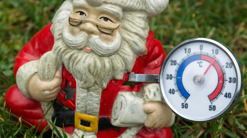 ILLUSTRATION: Eine Weihnachtsmann-Figur mit einem Thermometer, das knapp über 10 Grad Celsius anzeigt, ist am 19.12.2014 auf einer grünen Wiese in Sieversdorf im Landkreis Oder-Spree (Brandenburg) zu sehen. Mild, nass und trüb - kräftige Böen blasen 