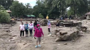 Ein Videostandbild zeigt Menschen, die am 24.12.2017 in einem von Tropensturm «Tembin» überschwemmten und zerstörten Gebiet in Lanao Del Norte (Philippinen) stehen. (zu dpa «Hunderte Tote und Vermisste nach Tropensturm auf den Philippinen» vom 24.12.2017) (Bestmögliche verfügbare Qualität) Foto: Uncredited/AP/dpa +++(c) dpa - Bildfunk+++
