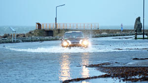 Ein Auto fährt am 03.01.2018 in Galway (Irland) über einen überschwemmten Parkplatz. Sturm Eleanor hat in der Nacht zum Mittwoch in Teilen Großbritanniens und Irlands erhebliche Schäden angerichtet. Foto: Brian Lawless/PA Wire/dpa +++(c) dpa - Bildfunk+++