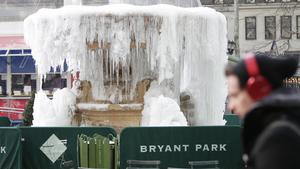 Bilder des Tages A pedestrian bundled up for cold weather walks by the frozen fountain in Bryant Park in below freezing temperatures in New York City on January 3, 2018. A massive winter storm called a bomb cyclone is set to batter the Northeast this week leaving the city blanketed in snow and battling harsh winds and temps as low as 4 degrees. PUBLICATIONxINxGERxSUIxAUTxHUNxONLY NYP20180103104 JOHNxANGELILLO  