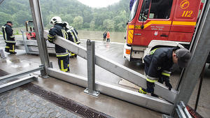 Feuerwehrmänner montieren am 01.06.2013 vor dem Kloster Weltenburg (Bayern) eine Hochwasserschutzwand. Extreme Regenfälle verschärfen die Hochwasserlage in Bayern und führen zu Überschwemmungen. Foto: Armin Weigel/dpa +++(c) dpa - Bildfunk+++