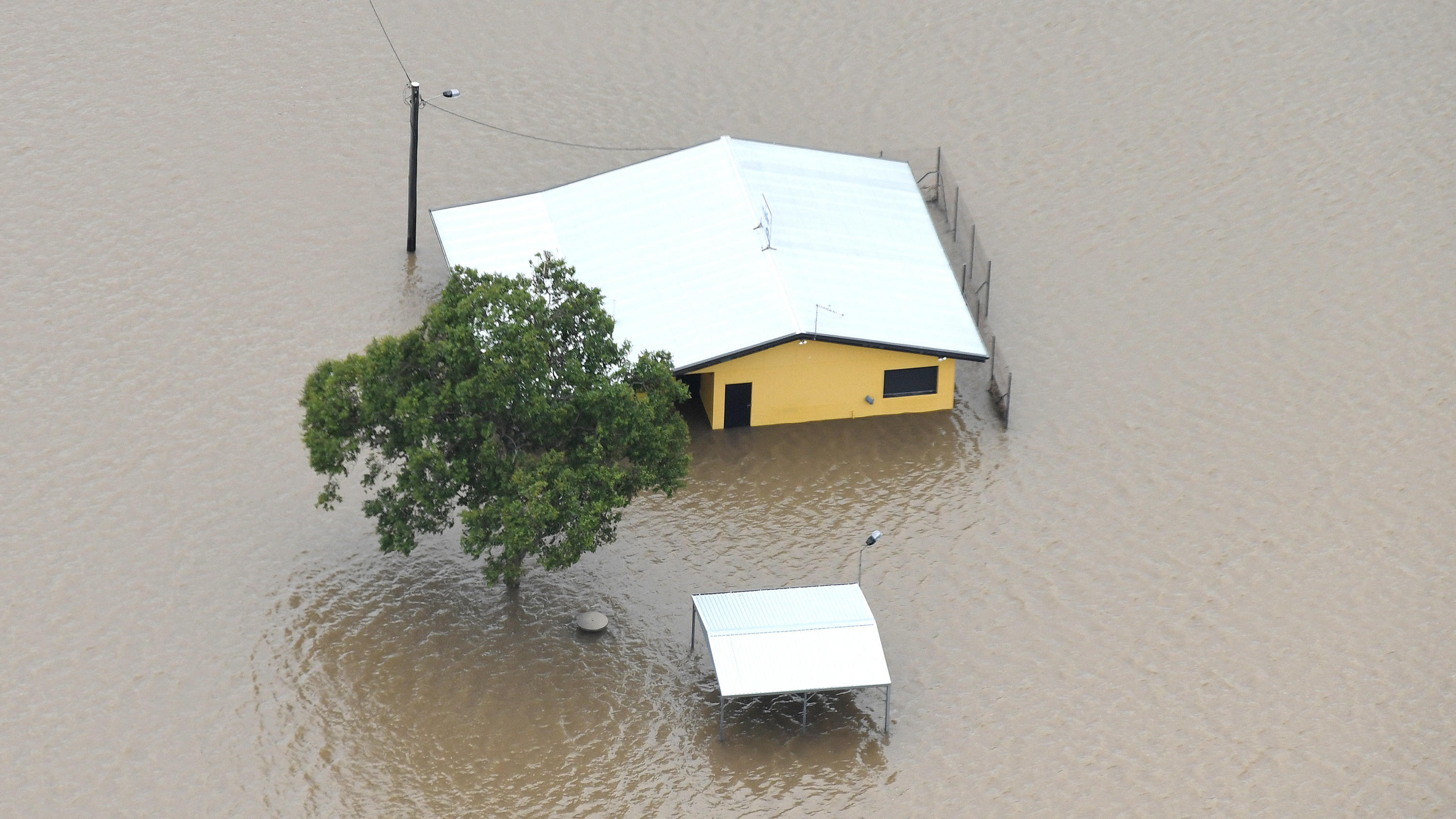 11.03.2018, Australien, Ingham: Häuser in Ingham im Bundesstaat North Queensland stehen unter Wasser. Die Gegend ist in den lettzen Tagen von heftigen Regenfällen geflutet worden. Foto: Dan Peled/AAP/dpa +++ dpa-Bildfunk +++